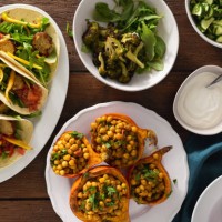 overhead view autumn dinner table with baked pumpkin with chickpeas curry, tortilla with falafel and salad - food stock pictures, royalty-free photos & images