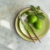 overhead view of a place setting decorated with two freshly picked limes - home decoration stock pictures, royalty-free photos & images