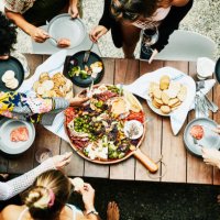 overhead view of group of friends enjoying buffet of food during party - food stock pictures, royalty-free photos & images
