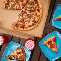 overhead view of pizza with blue plates and drinks on wooden table - junk food stock pictures, royalty-free photos & images