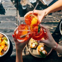 overhead view of three women making a celebratory toast with spritz cocktails - food stock pictures, royalty-free photos & images