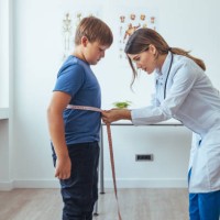 overweight boy with young female doctor in white coat - junk food stock pictures, royalty-free photos & images