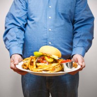 overweight man holding a very large plate of fried food - junk food stock pictures, royalty-free photos & images