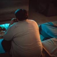 overweight man watching television - junk food stock pictures, royalty-free photos & images