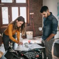 paar kijken naar renovatieplannen op hun nieuwe thuis - home decoration stockfoto's en -beelden