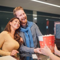 paar kopen popcorn in bioscoop - junk food stockfoto's en -beelden