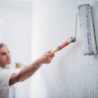 painter man at work with a paint roller - home decoration stock pictures, royalty-free photos & images