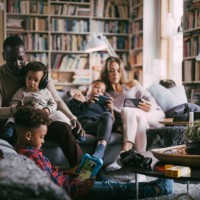 parents and sons using mobile phone while sitting on sofa in living room - home decoration stock pictures, royalty-free photos & images