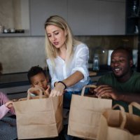 parents bringing take away food and serving at table to little children at home. - junk food stock pictures, royalty-free photos & images