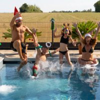 parents with two children jumping in swimming pool in christmas customs - garden decoration stock pictures, royalty-free photos & images