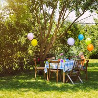 party table in garden with little boy - garden decoration stock pictures, royalty-free photos & images