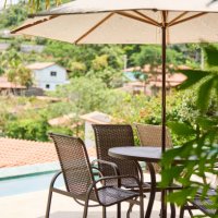 patio table and chairs with an umbrella sitting by a pool in summer - garden decoration stock pictures, royalty-free photos & images