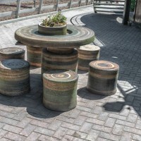 patio with stone round table - garden decoration stock-fotos und bilder