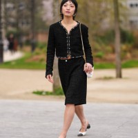Patricia Zhou wears silver Chanel earrings, black tweed pearl detail cropped Chanel blazer jacket, black mid-rise tweed bermuda Chanel shorts, white...