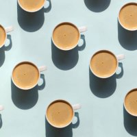 pattern made of cup of cappuccino on blue background - coffee stock pictures, royalty-free photos & images