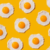 pattern of fried eggs against yellow background - food stock pictures, royalty-free photos & images
