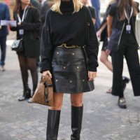 Pauline Chalamet wears a black wool turtleneck pullover, a black studded mini leather skirt, a brown leather Vuitton bag, knee high leather boots,...