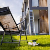 peindre l’équipement par chaise longue vide sur l’herbe contre l’appartement - garden decoration photos et images de collection