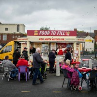 People eat fast food from a mobile caterer in Bilston on October 27, 2022 in Wolverhampton, England. A report from the Office for National Statistics...