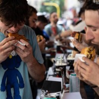 People eat hamburgers at Meat Crew fast food restaurant on May 28, 2023 in Milan, Italy. On occasion of the World Burger Day, celebrated on May 28...
