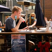 People eat take-out food outdoors at a 