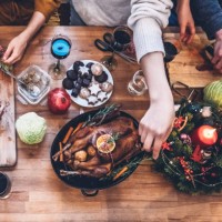 people preparing vegetarian christmas meal and goose roast together on wooden kitchen table - food stockfoto's en -beelden
