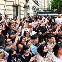 People stand across the street of the entrance of the 2024 Met Gala at the Metropolitan Museum of Art on May 6 in New York. The Gala raises money for...