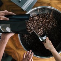 people working in roastery filling package - coffee stockfoto's en -beelden