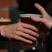 Person collecting a pint of lager beer in a plastic cup from the pub in Dublin's city center. On Thursday, 13 May 2021, in Dublin, Ireland.