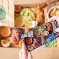 personal perspective human hand taking photo using smart phone on table top view malaysian food nasi kerabu, nasi ulam and ayam percik in recycled paper container with sauce - junk food stock pictures, royalty-free photos & i
