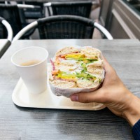personal perspective of a man eating bagel with salmon and creme cheese - junk food stock pictures, royalty-free photos & images