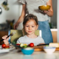 photo en gros plan d’une petite fille prenant le petit-déjeuner avec sa famille méconnaissable - food photos et images de collection