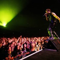 Photo of Bruce DICKINSON and IRON MAIDEN, Bruce Dickinson performing live onstage, standing at front of stage, looking out over cheering, waving fans...