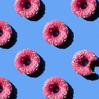 pink doughnut on pastel blue background. chewed donut. - food stock pictures, royalty-free photos & images