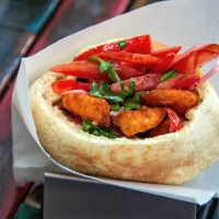 pita bread filled with breaded shrimp, sliced tomato, pickled red onion and arugula - junk food stock pictures, royalty-free photos & images