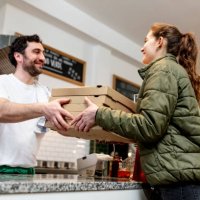pizzaiolo at work - chef is shovelling fresh prosciutto pizza in the carton pizza box - junk food stock pictures, royalty-free photos & images