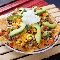 plate of nachos with avocado, cheese and vegetables - junk food stock pictures, royalty-free photos & images