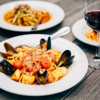 plates of seafood and pasta with wine glasses - food stock pictures, royalty-free photos & images