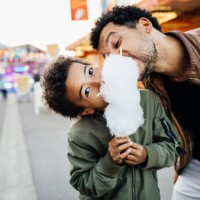 playful father and son sharing candy floss - food stock pictures, royalty-free photos & images