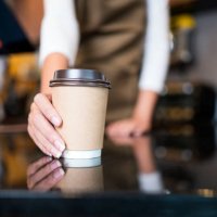 please enjoy drinking a coffee. the unrecognizable waitress serving coffee to a customer in a cafe. serving food and drink, point of sale system. - coffee stockfoto's en -beelden