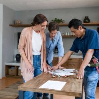 plumber fixing a pipe and talking to his clients in the kitchen - home decoration stock pictures, royalty-free photos & images