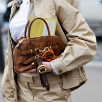 Polina Erofeeva wears white t-shirt, beige Miu Miu jacket with blue checked details, matching mini skirt, brown Miu Miu bag, outside Miu Miu, during...