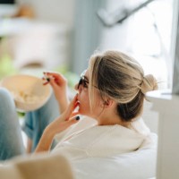 popcorn and 3d movie on weekends. woman in 3d glasses eating popcorn and watching tv at home - junk food stock pictures, royalty-free photos & images