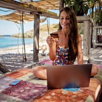 portrait d’une jeune femme faisant ses courses en ligne/faisant une réservation dans un bar de plage - travel photos et images de collection
