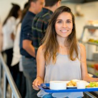 portrait de la belle jeune femme dans un restaurant buffet, tenant son plateau et regardant sourire caméra - food photos et images de collection