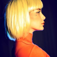 portrait in profile of young woman with yellow hair. yellow and blue lighting, red turtleneck on woman, mock-up for your design with copy space. - fashion stock pictures, royalty-free photos & images