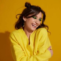 portrait of a beautiful smiling girl with bright makeup and wavy hair on a bright yellow background - fashion photos et images de collection