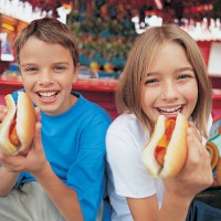 portrait of a brother and sister holding hot dogs - food stock pictures, royalty-free photos & images