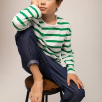 portrait of a curly-haired boy in a vest and jeans on a white background in the studio - fashion photos et images de collection