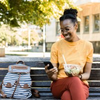 portrait of a happy afro young woman ready to eat her salad to go - junk food stock pictures, royalty-free photos & images